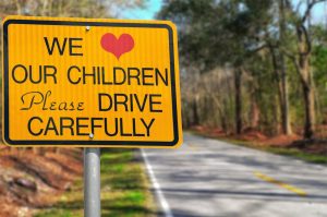 We love our children please drive carefully sign on road