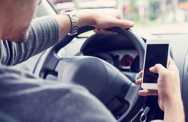 man texting while driving, distracted driving