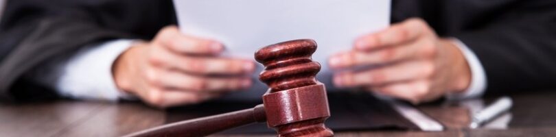 Judge In Front Of Mallet Holding Documents