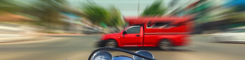 car running red light as motorcycle approaches the intersection