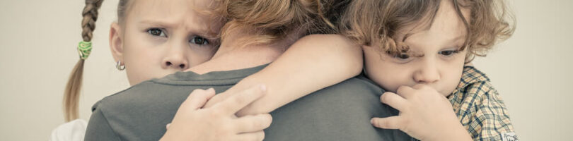children hugging their mother after wrongful death in family