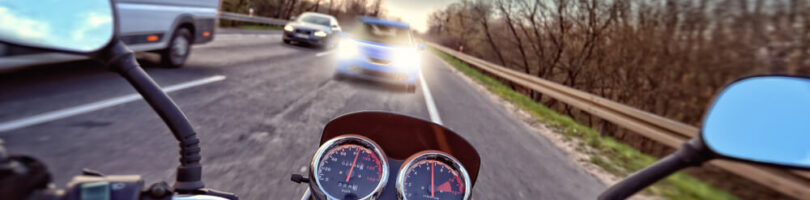 car in passing lane about to hit a motorcyclist