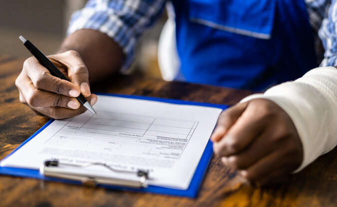 worker with wrist injury filling out a workers compensation claim