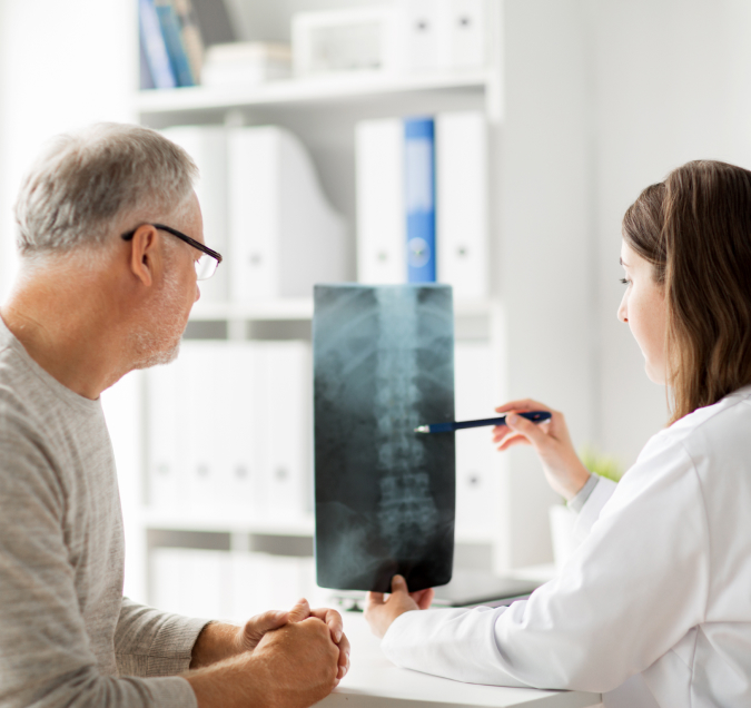 doctor showing patient x-ray image of spinal cord injuries