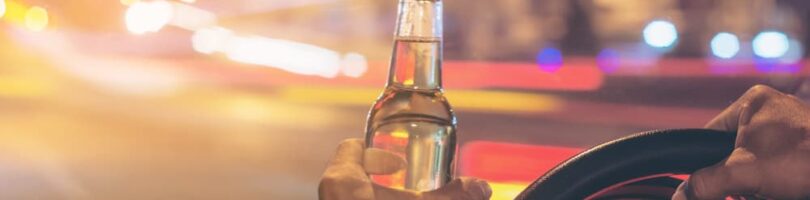 driver with open container in hand while operating the vehicle