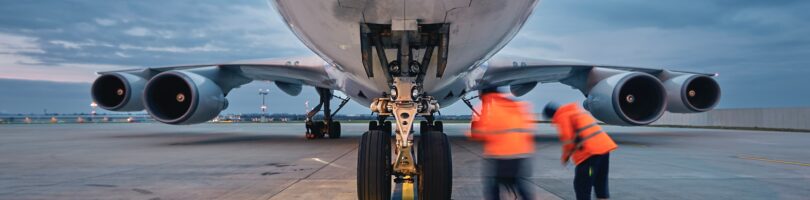 airline employees servicing a airplane wheels