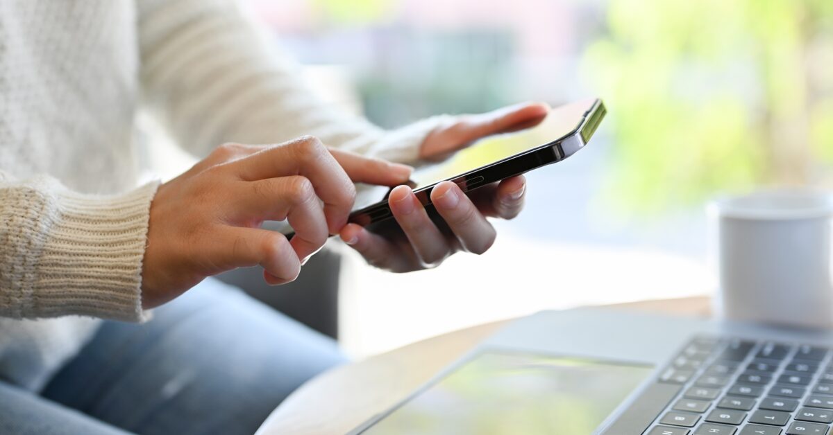 workers comp claimant sitting at computer and holding a phone waiting for a reponse.